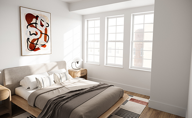 Model bedroom at Shoregate Apartments in Bay Shore, featuring wood grain floor paneling and three windows.