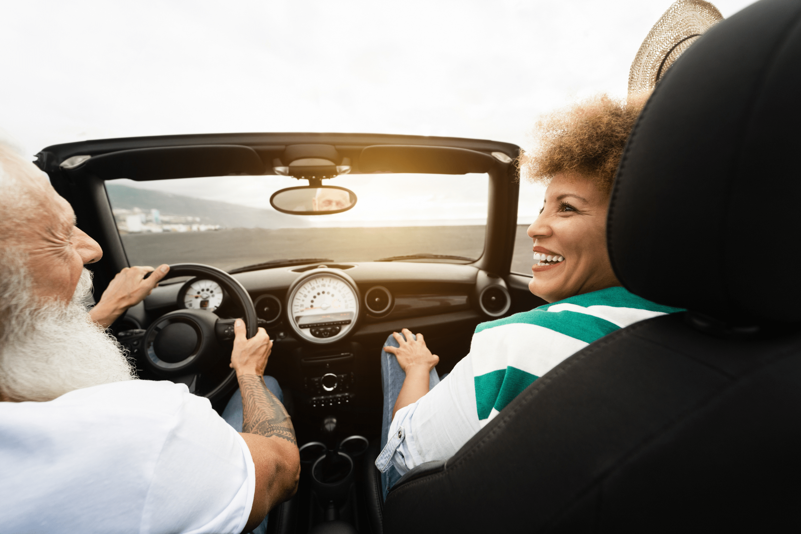 couple smiling in car on the beach